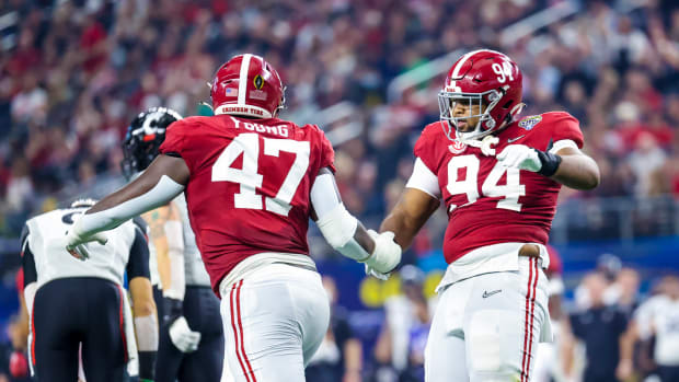 Alabama Crimson Tide defensive lineman DJ Dale (94) celebrates with defensive lineman Byron Young (47) after making a sack during the first half against the Cincinnati Bearcats in the 2021 Cotton Bowl college football CFP national semifinal game at AT&T Stadium.